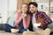 Happy young couple watching basketball game on tv at home