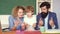 Happy young couple who are standing with their son at graduation. Little child school boy in first grade. Family