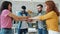 Happy young coworkers multi-ethnic team putting arms together in office