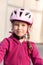 Happy young cyclist portrait, little school age child in a bicycle helmet, vertical shot, face closeup. Young caucasian girl