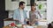 Happy young european couple talking, preparing food in kitchen.