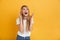 Happy young excited shocked blonde woman posing isolated over yellow wall background