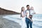 Happy young family against the sea. Beautiful couple with child. Family vacation concept