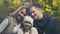 Happy young family with beautiful daughter posing for camera in autumn forest