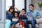 Happy young family eating popcorn while watching tv