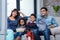 Happy young family eating popcorn while watching tv