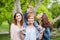 Happy young family enjoying free time in the park, mother, sisters and brother