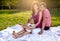 Happy young family having picnic at meadow