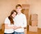 Happy young family hugging on a background of cardboard boxes