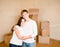 Happy young family hugging on a background of cardboard boxes