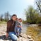 Happy young family with little daughter near the mountain river