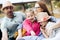 Happy young family- mom,dad and two children teenage girl and little daughter traveling together and relaxing in street cafe