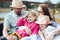 Happy young family- mom,dad and two children teenage girl and little daughter traveling together and relaxing in street cafe