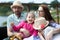 Happy young family- mom,dad and two children teenage girl and little daughter traveling together and relaxing in street cafe