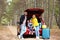 Happy young family near car trunk loaded with suitcases