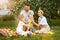 The happy young family during picking apples in a garden outdoors