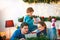 Happy young family with son on Christmas reading book together