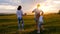 Happy Young Family with two children running on summer field. Healthy mother, father and little children enjoying nature