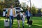 Happy young family walking with suitcases, coming home from caravan trip outdoors in garden