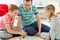 Happy young father plays with his two cheerful siblings children Board Game with colorful dices