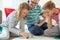 Happy young father plays with his two cheerful siblings children Board Game with colorful dices