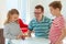 Happy young father plays with his two cheerful siblings children Board Game with colorful dices