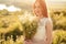 Happy young female with flowers in nature