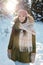 Happy young female in winterwear standing in the forest