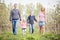 Happy young four member family walking together outdoors in orc