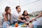 Happy young friends were sitting at a table and having a picnic outdoors