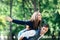 Happy young girl on back of guy portraying bird