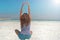 happy young girl with her hands is catching the energy of the sun. long-haired girl sits on the shore of blue Dead Sea in Israel.