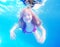 Happy young girl with long haired underwater in pool