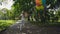 Happy young girl runs in the green sunny park and holds colourful balloons