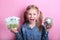 Happy young girl with silver piggy bank and euro banknotes  on pink background. save money concept.