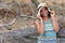 Happy young girl with straw hat enjoying her summer vacation. Portrait of a beautiful latina relaxing on the beach and looking at