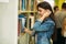 Happy young girl student studing in library