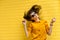 Happy young girl in sunglasses against a bright yellow wall. Sunny and summer mood