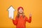 Happy Young girl in sweater and hat holding paper arrow