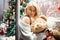 Happy young girl with a teddy bear near a decorated Christmas tree.New Year