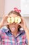 Happy young girl with two apples near her eyes showing her toungue