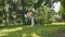 Happy young girl walks and poses with colourful balloons at camera in park.