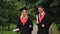 Happy young graduates dancing and celebrating graduation in park near academy