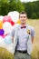 Happy young groom holding in hands colorful latex balloons