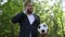 Happy young handsome African American man in formal suit talking on the phone holding soccer ball standing in park