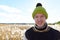 Happy young handsome man smiling against scenic view of autumn bulrush field