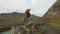 Happy young hiker tourist traveler man backpack with arms raised on top of mountain