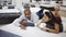 Happy young hispanic couple testing softness of new mattress in modern furniture showroom