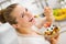 Happy young housewife eating fruits salad