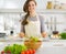 Happy young housewife mixing vegetable salad